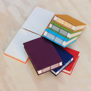 Stack of colorful books on a light wooden surface