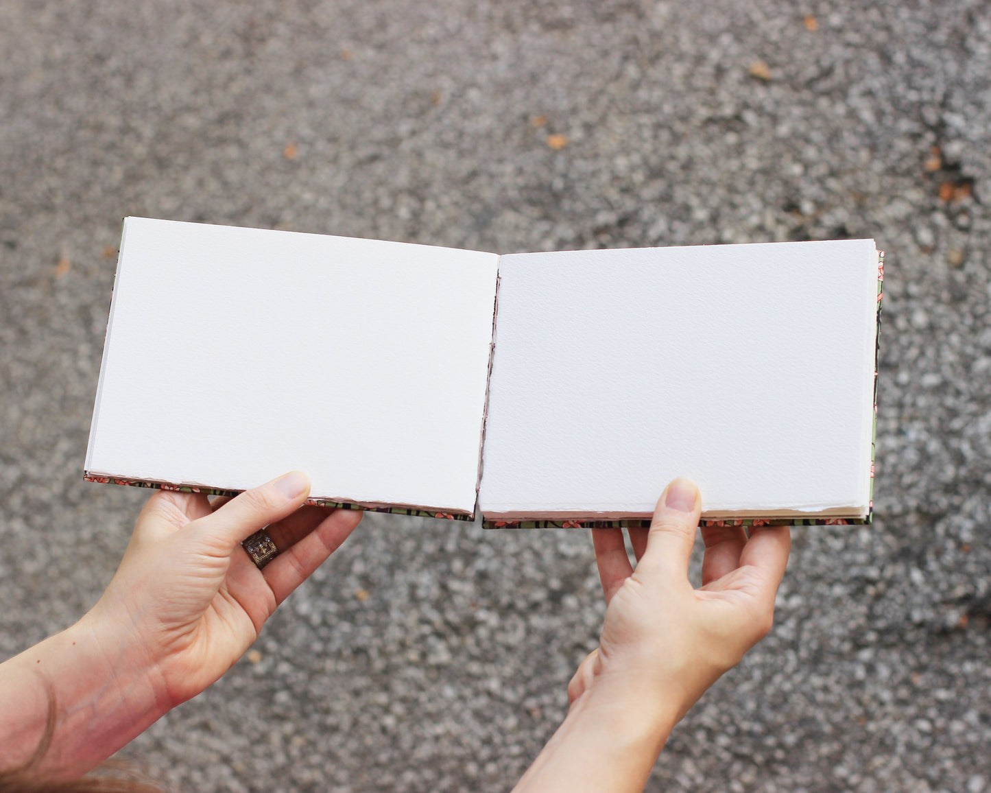 open sketchbook held by two hands