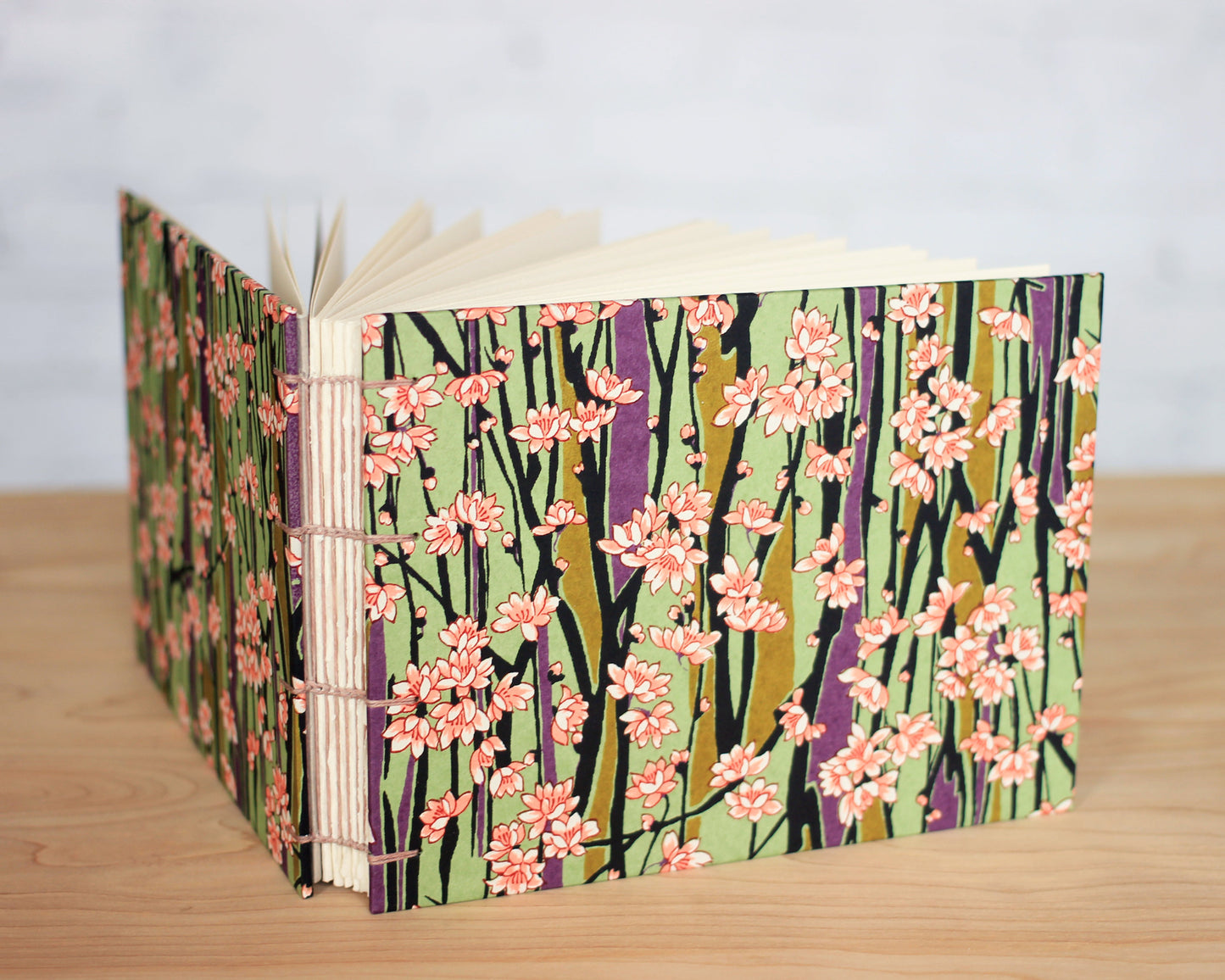 A sketchbook with a floral pattern on the cover, featuring books with a spine and pages visible.