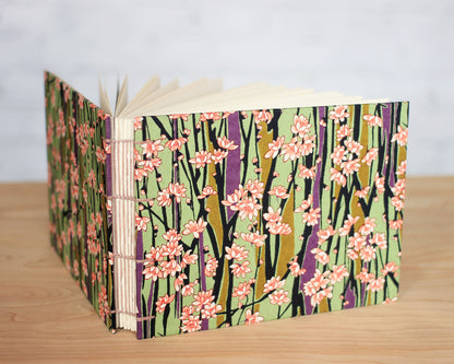 A sketchbook with a floral pattern on the cover, featuring books with a spine and pages visible.