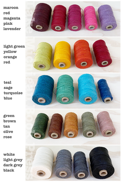 Assorted spools of thread in various colors on a white background