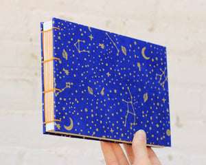 blue watercolor sketchbook with moon, stars and planets