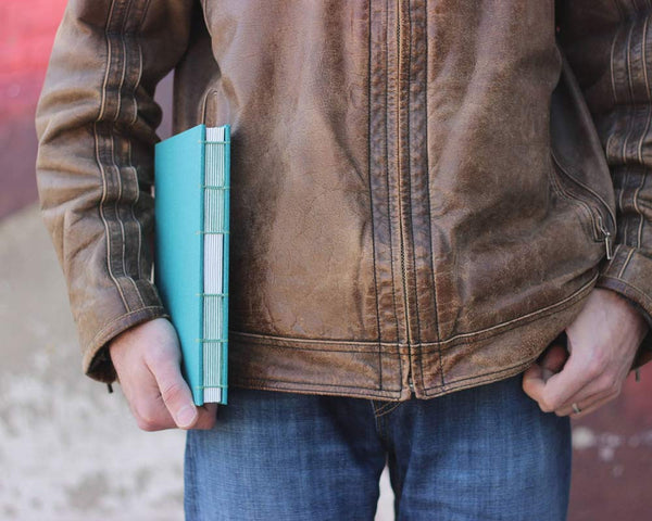 Load image into Gallery viewer, man holding teal sketchbook
